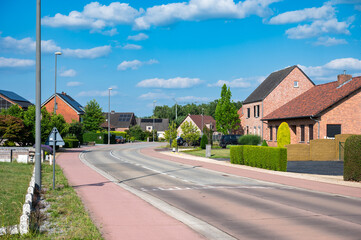 Village road with double cycling path through residential area in Tessenderlo, Limburg, Belgium