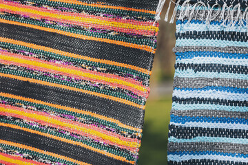 Woven textures tell tales of far away lands and vibrant artistry, showing rugs swaying gently on a...