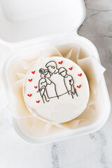 Small trendy bento cake decorated with silhouette of happy family together drawing. Happy International Father's Day cake in a gift box