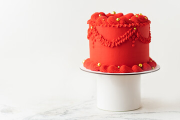 Delicate lambeth style birthday cake with red cream cheese frosting decorated with cream tracery...