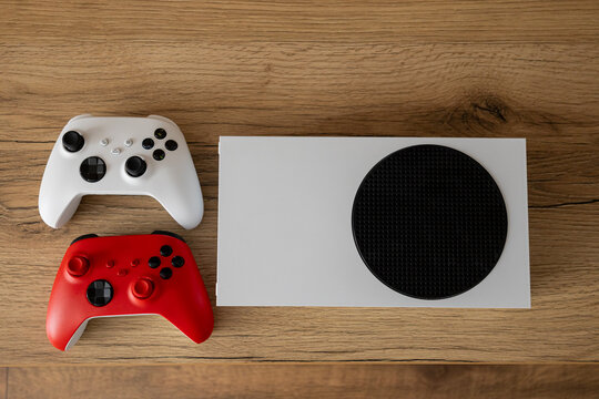 Modern Gaming Console with Red and White Wireless Controllers