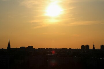 Silhouettes of Novi Sad's skyline during golden hour, with church spires and buildings under a...