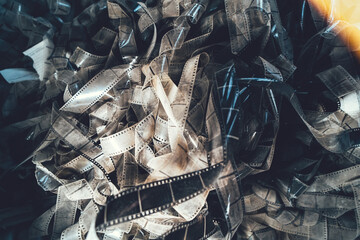 Tangled pile of old damaged 35mm filmstrips, retro photography, analog media, cinematic heritage, nostalgia.