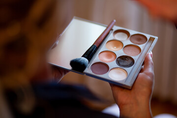 Holding makeup palette with brush