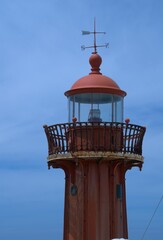 Red iron lighthouse structure, state owned historical navigation aid atop the Fort of Saint Catarina in Figueira da Foz Portugal