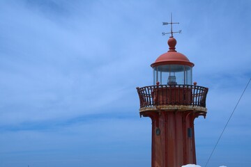 Red iron lighthouse structure, state owned historical navigation aid atop the Fort of Saint...