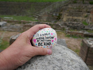 Be kind kindness rock with out of focus ancient amphitheater in background