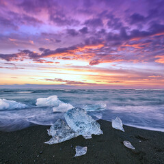 Impressive pieces of the iceberg sparkle on famous Diamond Beach at  Jokulsarlon lagoon during...