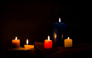 Velas encendidas de colores en ambiente oscuro para meditación, relajación o decoración espiritual