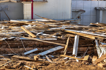 Construction debris with wood, wires, and broken tiles. The photo illustrates demolition waste,...