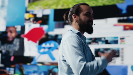 With a hands free microphone, male trend setter hosts a live presentation offering insight for...