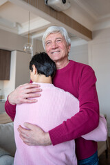 Cheerful happy older husband hugging wife spouse with affection. Peaceful healthy partnership, enduring love in family, emotional security, husband care and stable union, shared life joy together