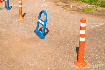 Blue metal parking barrier and orange cones in a car park