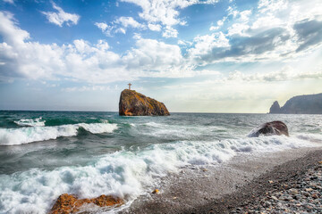 Amazing view of sea waves crashing on the shore and flowing above seashore pebbles.