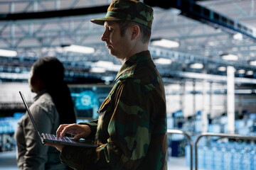 Soldier maintaining secure military networks inside data center facility. Army information...