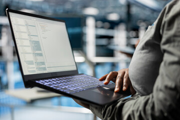 Close up of laptop used by data center software developer to upgrade system stability. Server hub...
