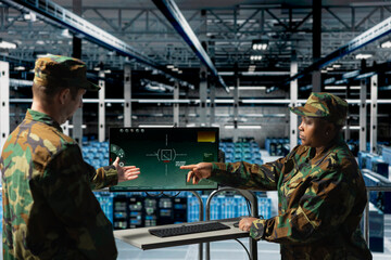 Army soldiers in data center using digital crosshairs to lock onto enemy targets. Military units in...