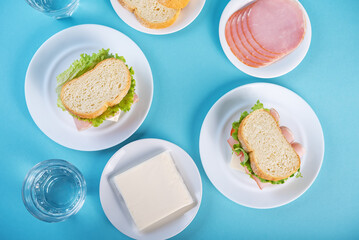 Sandwich with ham, cheese and lettuce on a blue background