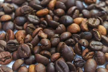 Top view background of aromatic brown coffee beans scattered on surface.