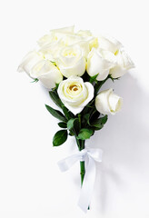 Fresh bouquet of white roses. Flowers tied with a white ribbon on a white background.