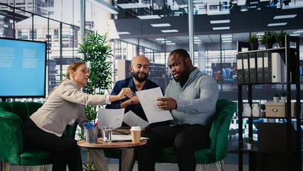 Diverse business professionals using analysis tools to extract details and insights for career...