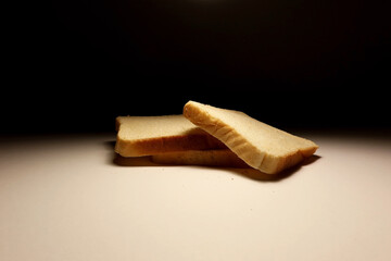 Minimalist studio photo of white bread slices with dramatic lighting on a white background, perfect...