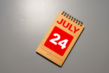 Female Hand holding wooden block calendar with the date July 24