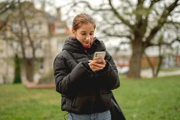 Smiling Girl Holding Smartphone In The Park