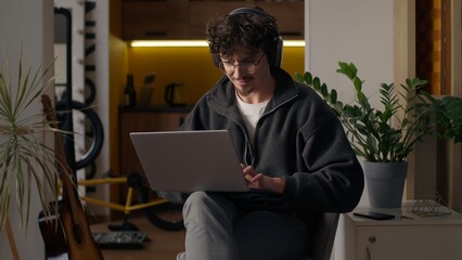 Glad Hispanic guy worker using laptop at home man freelancer typing computer programmer work remote...