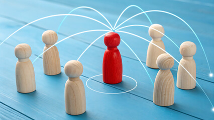 Obraz premium Leadership and Network: A wooden figures network, with one figure standing out. This imagery captures the essence of teamwork, collaboration, and interconnectedness.