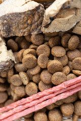 There are different kinds of pet treats in the bowl. Crispy breakfast cereals, chewing gums and pieces of dried meat. For the care of pets and their proper nutrition.