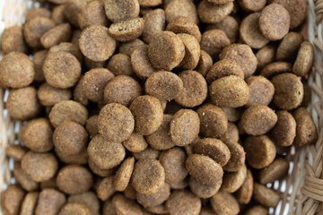 There are different kinds of pet treats in the bowl. Crispy breakfast cereals, chewing gums and pieces of dried meat. For the care of pets and their proper nutrition.