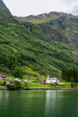 Idyllic village and church on a green fjord shore