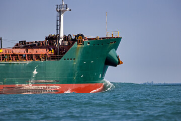Closeup of the bow of a freighter traveling across a lake.