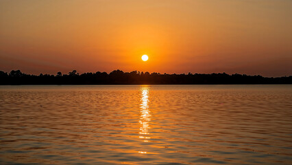 Naklejka premium Golden hour serenity over a tranquil lake