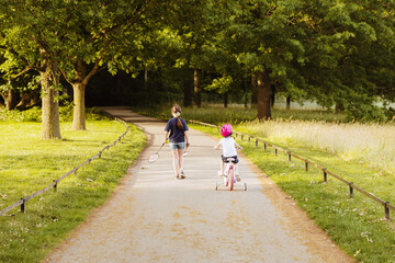 Children walking along a path in a park.