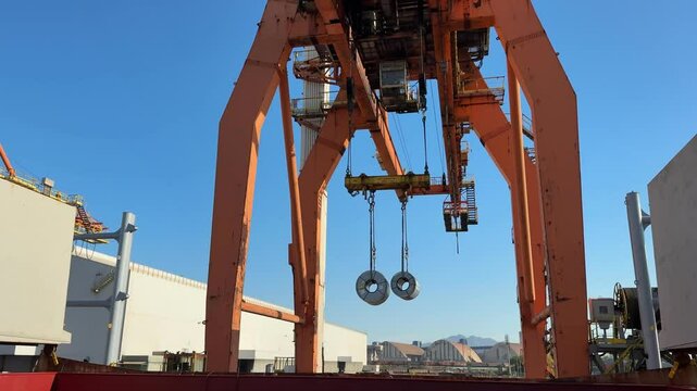 loading steel coils to the cargo ship. crane in port. how it is working.