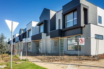 A row of newly built modern townhouses under construction in a suburban neighborhood in Australia....