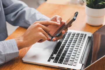 Laptop, hands and businessman with cellphone in office for online email communication for corporate review. Technology coffee and hr with computer and phone for reading company policy on internet,