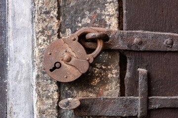Vintage rustic padlock on weathered metal door