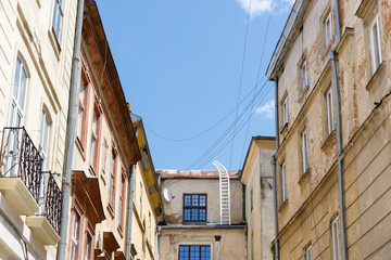 Captivating View of Historic Architecture Against a Clear Blue Sky in a Charming European Alleyway, Highlighting the Unique Textures and Character of Old Buildings