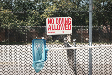 No diving sign on pool fence with skimmer