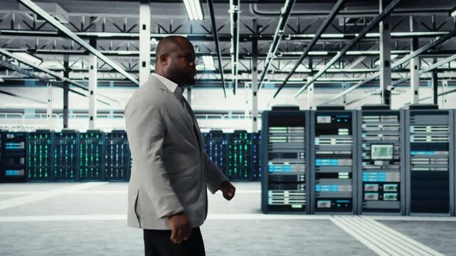 System administrator walking in data center with rigs handling queries, doing backups. Admin overseeing server farm with gear hosting digital services, powering client platforms, camera A