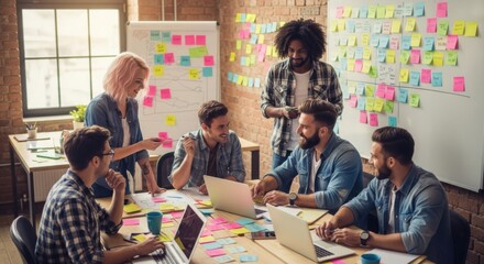 Diverse team collaborates on innovative project using colorful sticky notes and laptops in a modern office setting brainstorming ideas for success