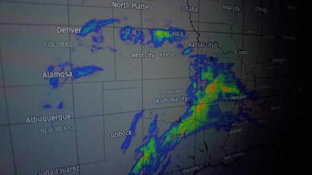 Close up shot of a weather radar screen displaying a map of the United States with storms moving across the south-central region. The camera is static.