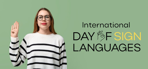 Young deaf mute woman using sign language on green background