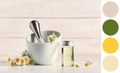 Bottle of chamomile cosmetic oil and mortar with flowers on white wooden background
