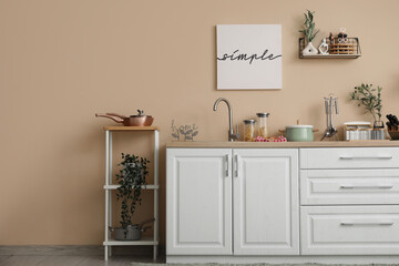 Interior of kitchen with counters, shelf unit and utensils