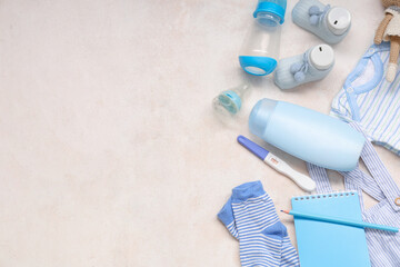 Composition with baby clothes, notebook, pregnancy test and nipples on grunge white background © Pixel-Shot