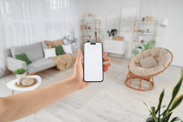 Woman with blank mobile phone at home, closeup